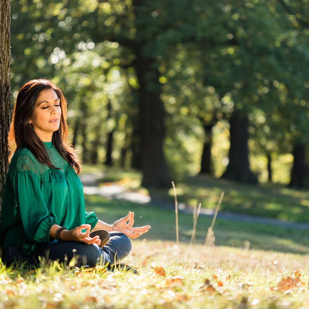 Priya Khan sitting in a sunlit park